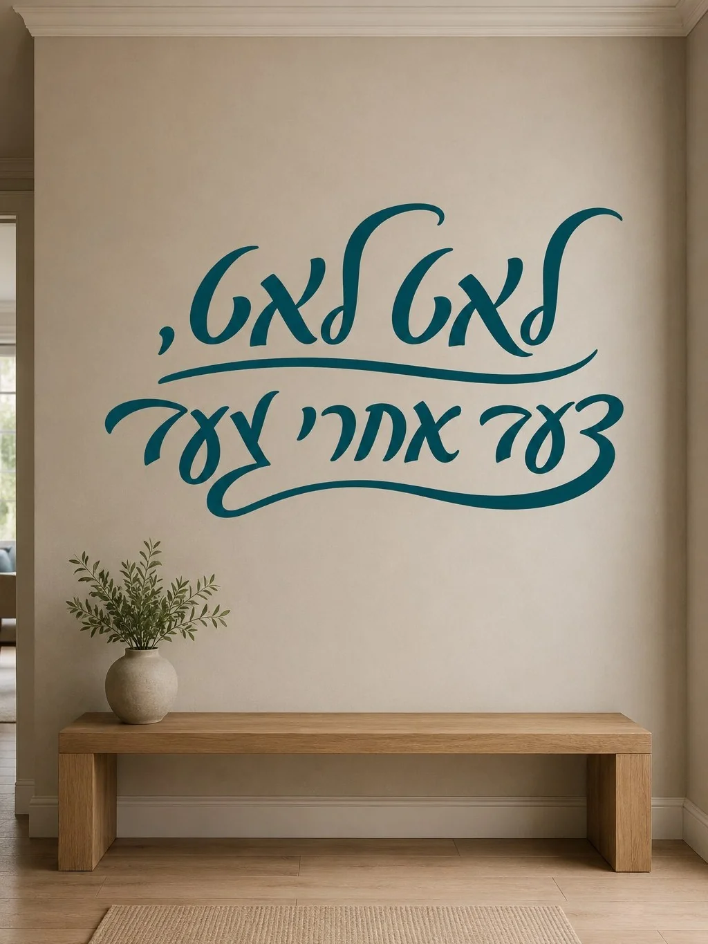 מדבקת קליגרפיה עברית על קיר בחדר מגורים עם ספת עור אפורה ותאורה רכה