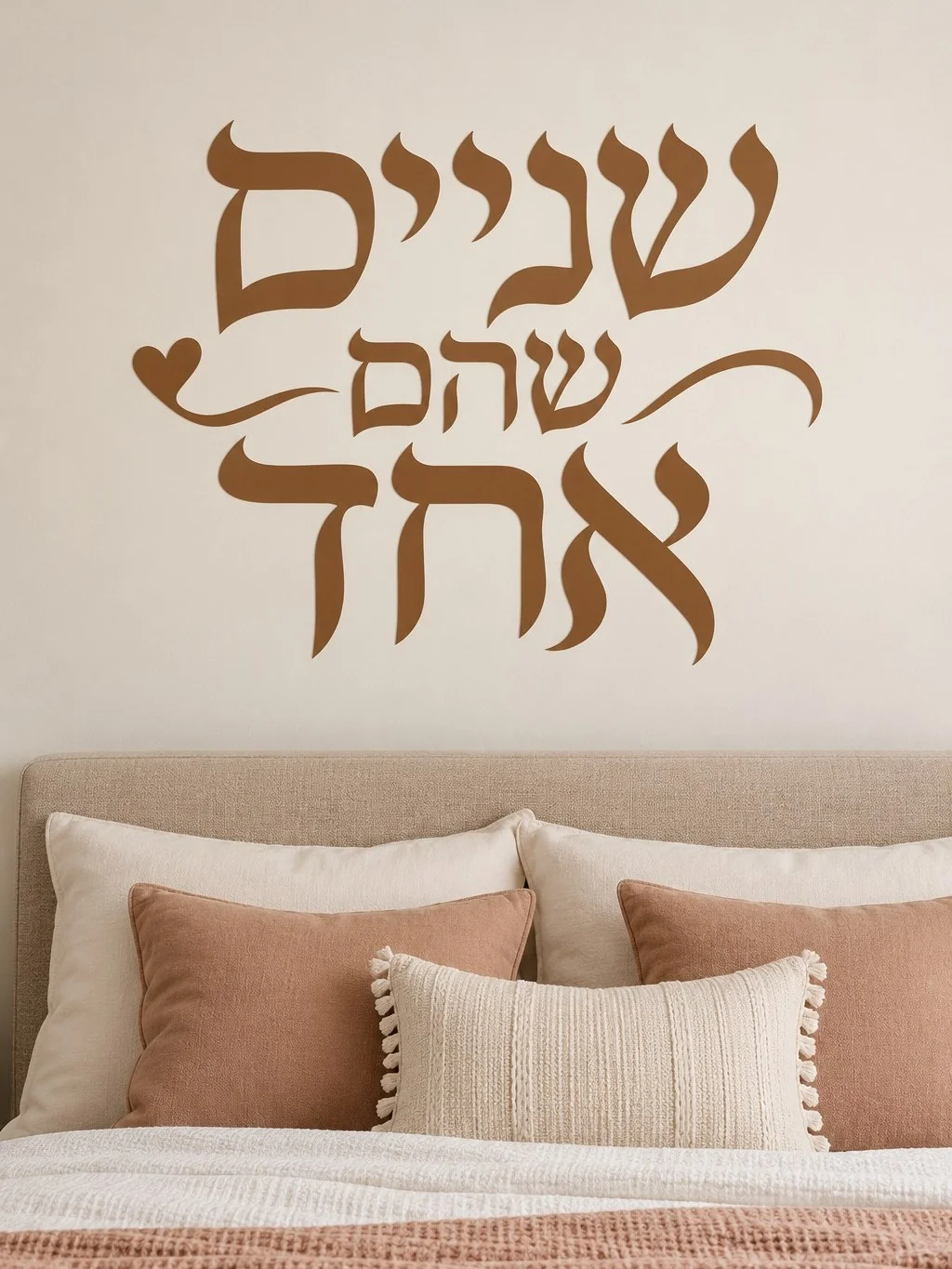 מדבקת קליגרפיה עברית על קיר בסלון עם כורסה אפורה ותאורה רכה ברקע.