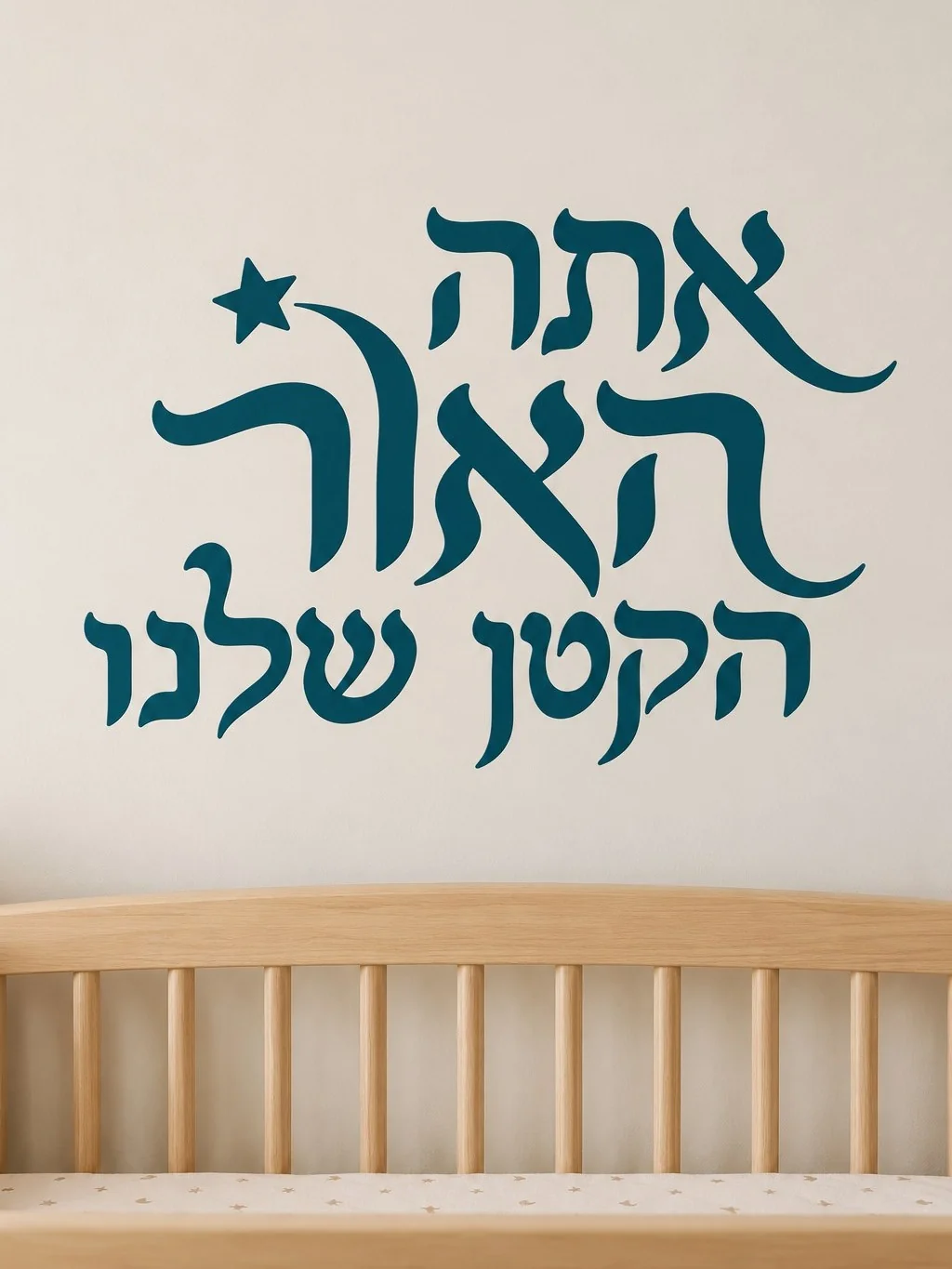 מדבקת טקסט עברי עם כוכב על קיר בסלון מודרני עם כורסה אפורה ושולחן קפה עץ.