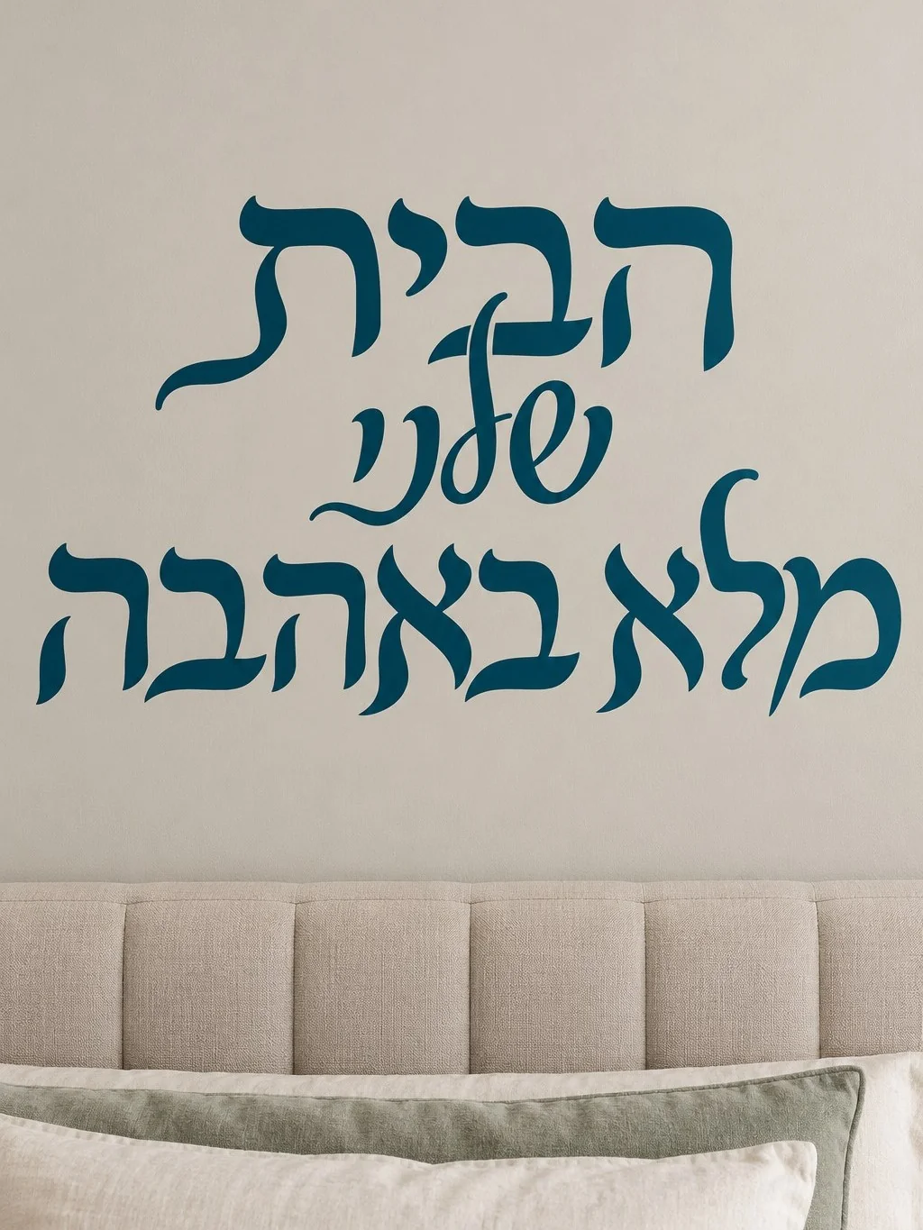 מדבקת קליגרפיה עברית על קיר בסלון עם רהיטים מודרניים, תאורה רכה וסביבה נעימה.