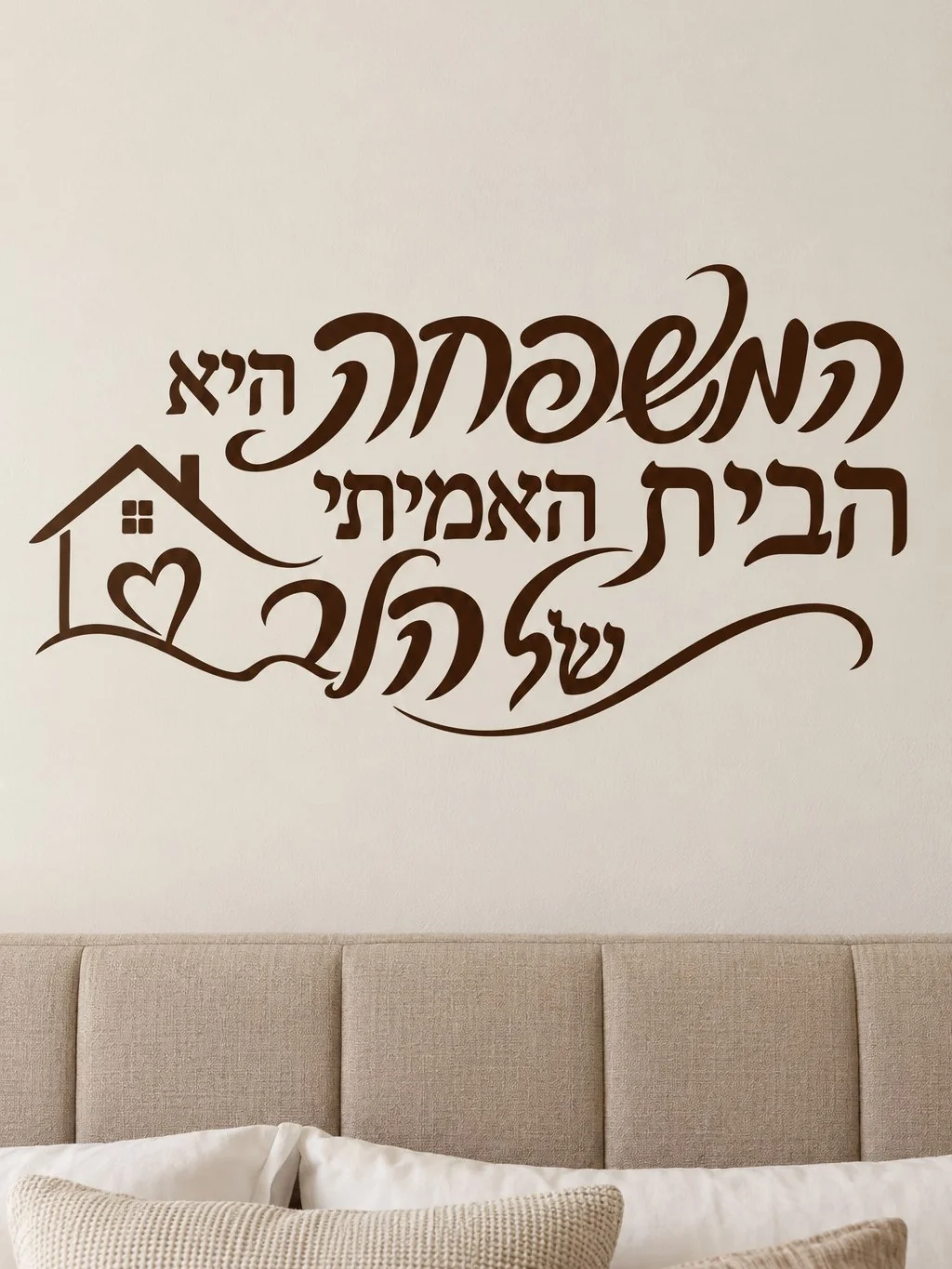 מדבקה עם טקסט עברי ובית על קיר בחדר מגורים מודרני עם תאורה מעודנת וריהוט עץ בהיר.