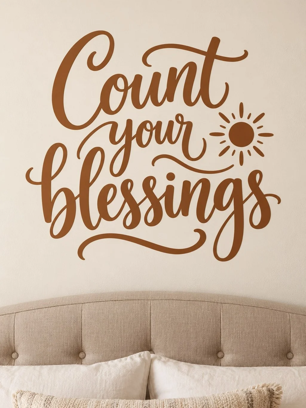 מדבקה עם כיתוב 'Count your blessings' ושמש קטנה על קיר בחדר בהיר עם ריהוט מודרני.